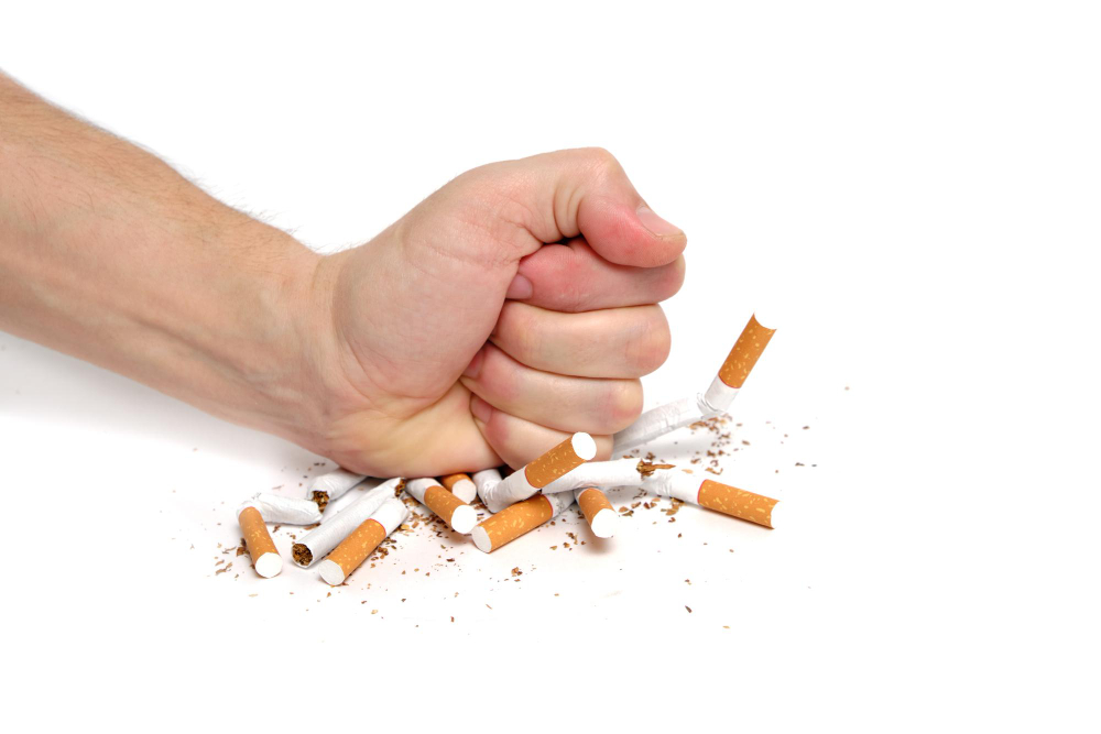man-crushes-cigarettes-with-his-fist-refusing-smoke-white-background